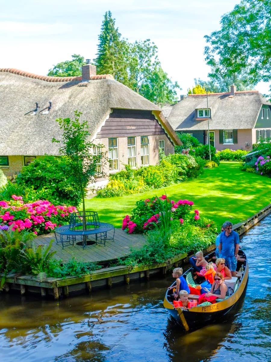 Thatched-roof farmhouses and a canal boat in Giethoorn