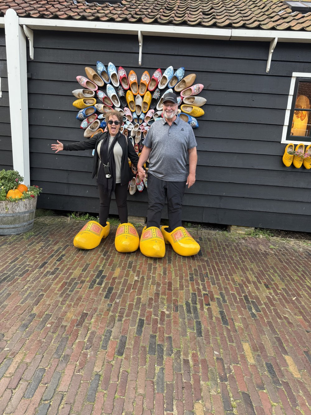 Guests laughing in giant clogs at Zaanse Schans, photographed by Mike during a tour